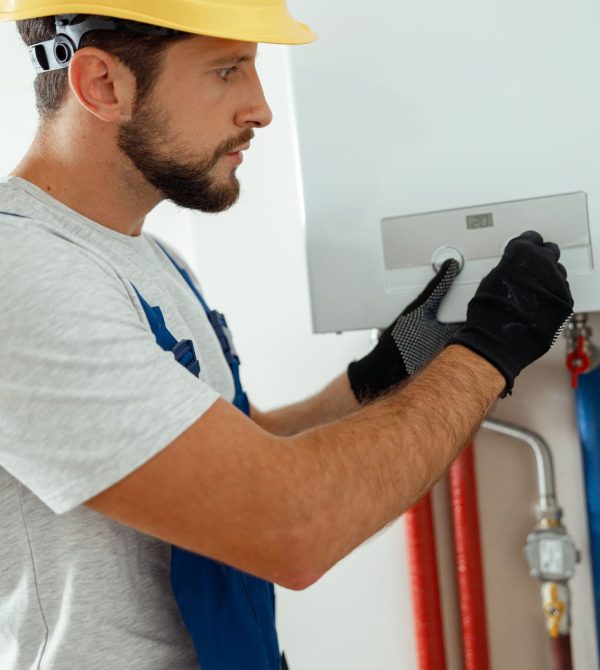 serious-technician-setting-the-new-gas-boiler-for-2022-03-07-19-09-48-utc
